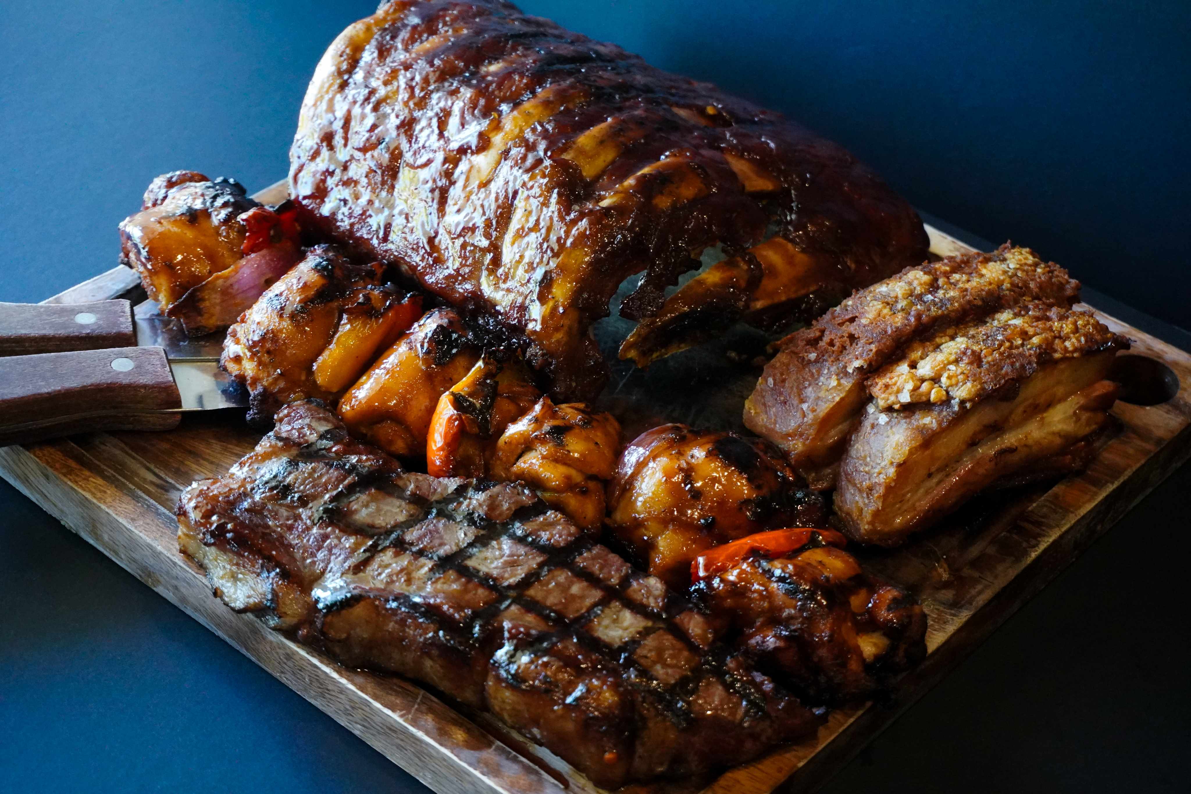 Big shared platter with ribs, pork belly, steak and sides